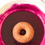 Dipping donut in blueberry glaze