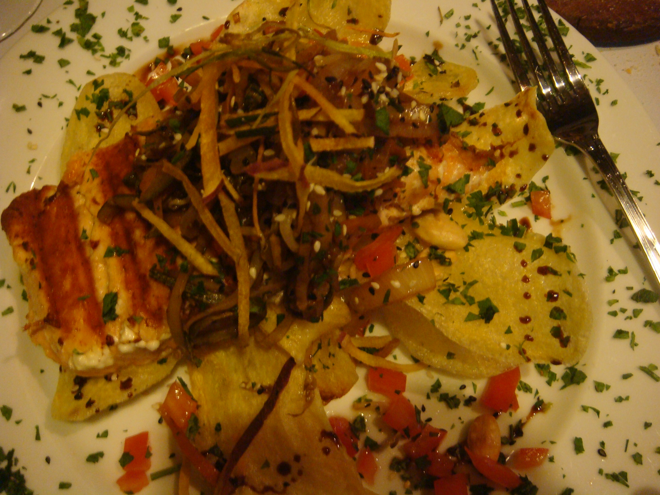 Grilled salmon and crispy potato slices, garnished with sauteed vegetables