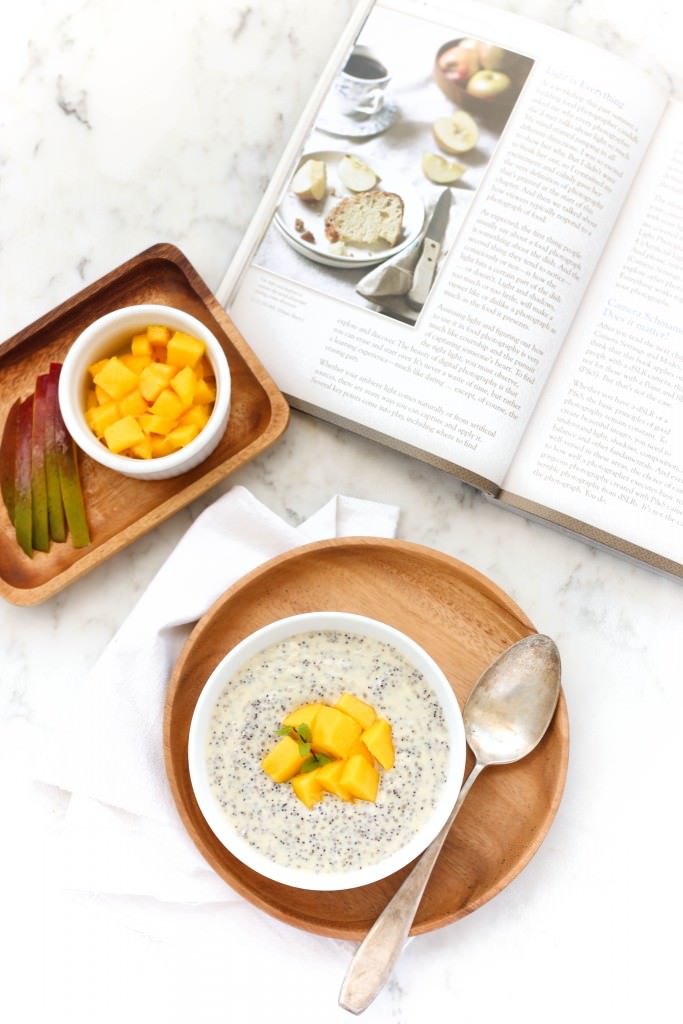 Chia seed pudding topped with fresh mangoes on wooden plate.