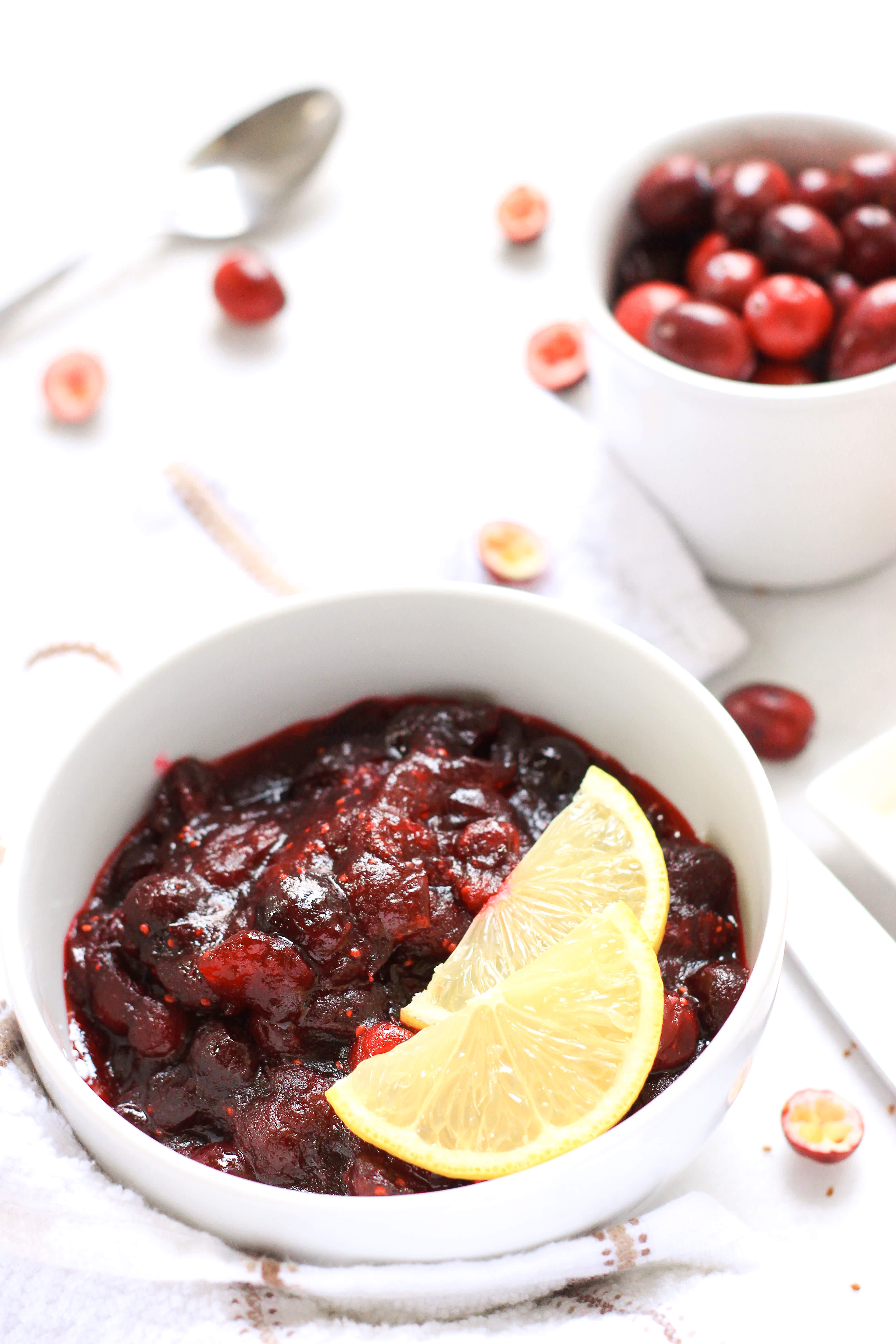 Cranberry sauce in a bowl with lemon slices.