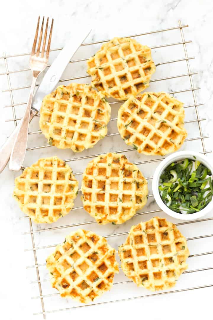 Fork and knife and mashed potato waffles on wire rack.