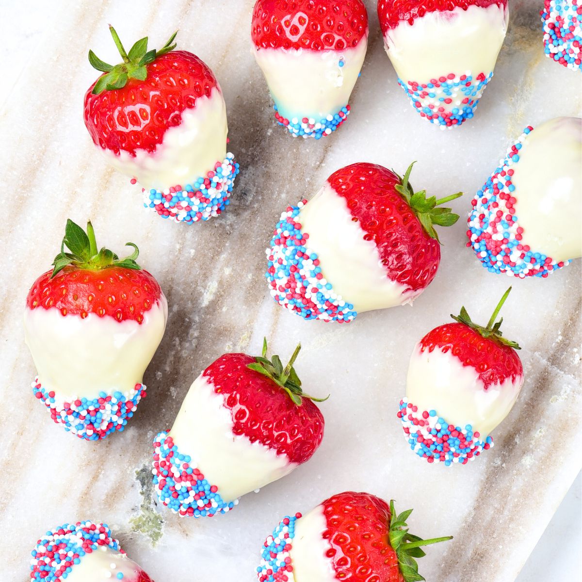 Top down view of white-chocolate covered strawberries coated in sprinkles.