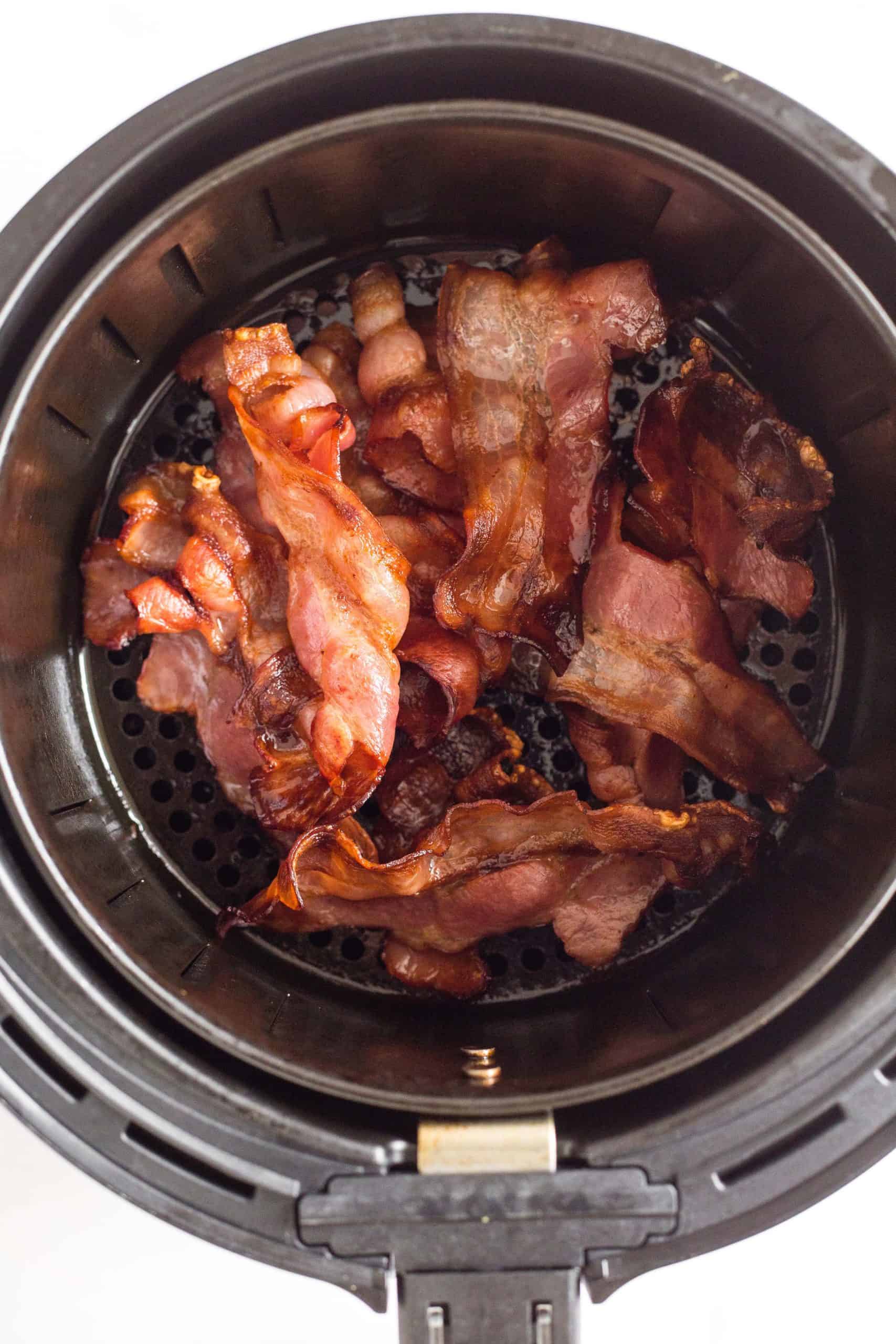 Air fryer bacon in an air fryer basket.