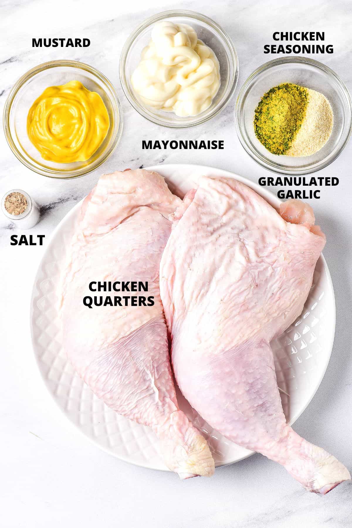 Ingredients for chicken leg quarters laid out on marble board.