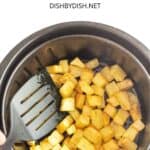 Tossing diced potatoes in the air fryer basketthe