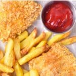 Top down view of gluten-free fish and chips on parchment paper.