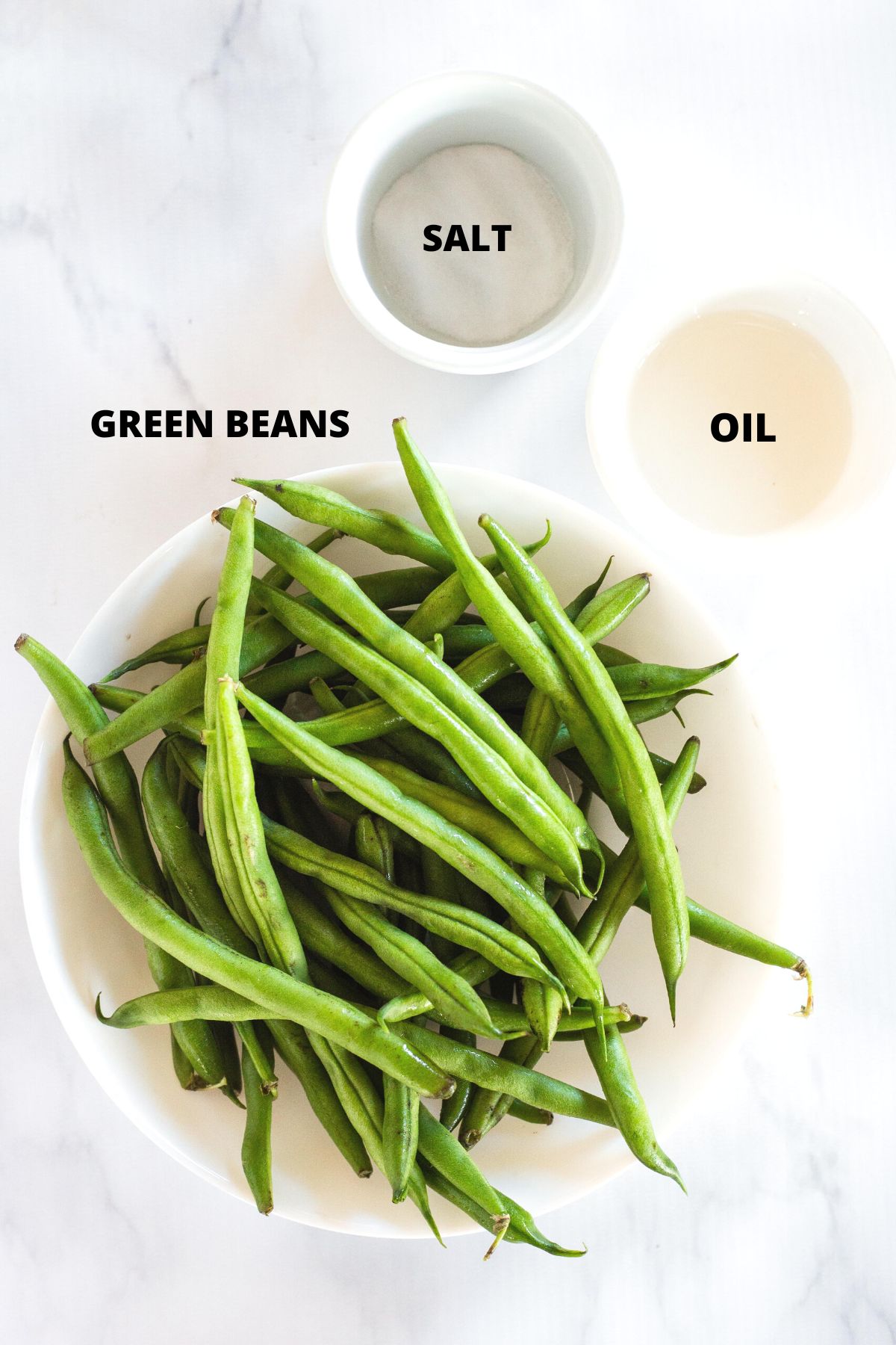 Ingredients required for air fryer green beans laid out on marble board.