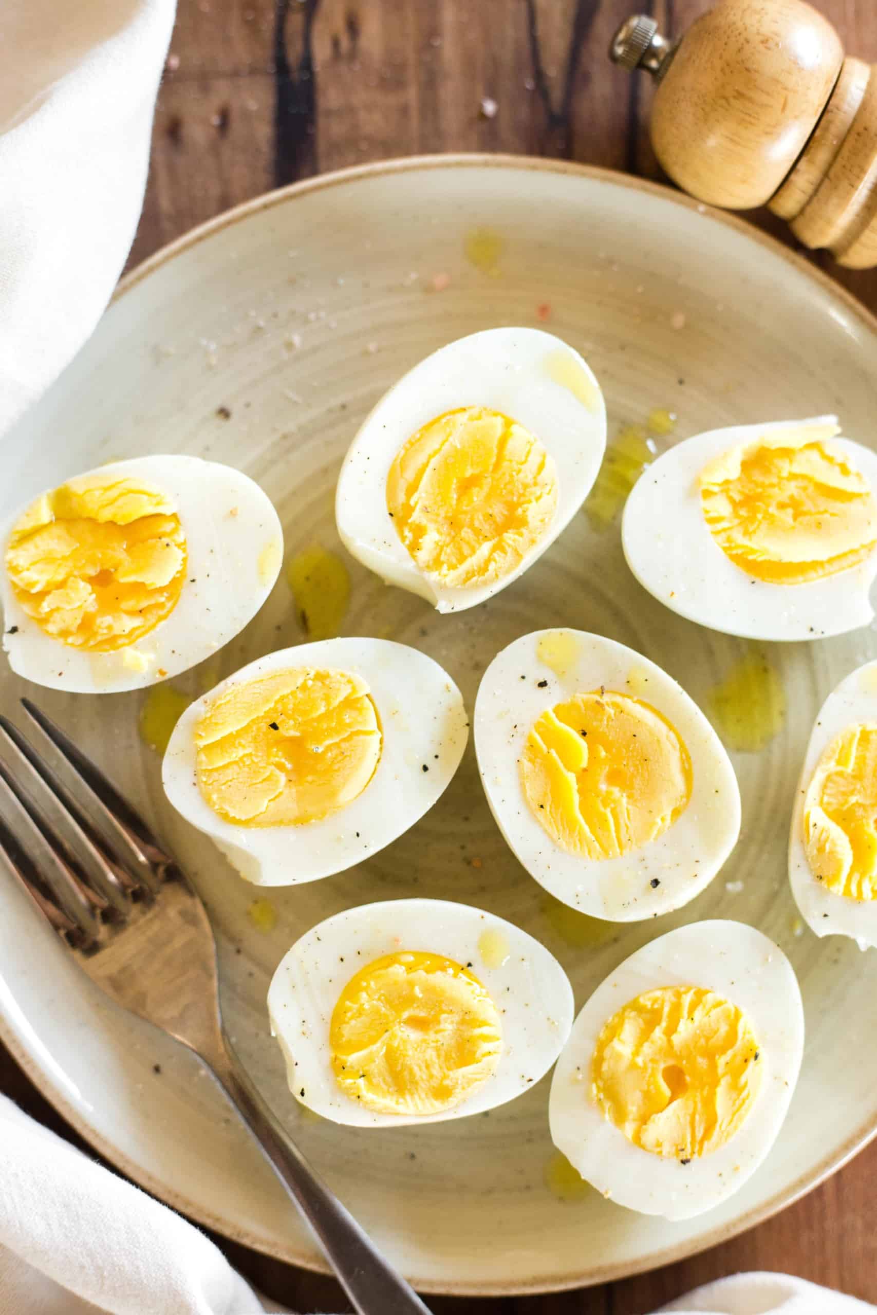 Sliced air fryer hard boiled eggs with a fork on a plate.