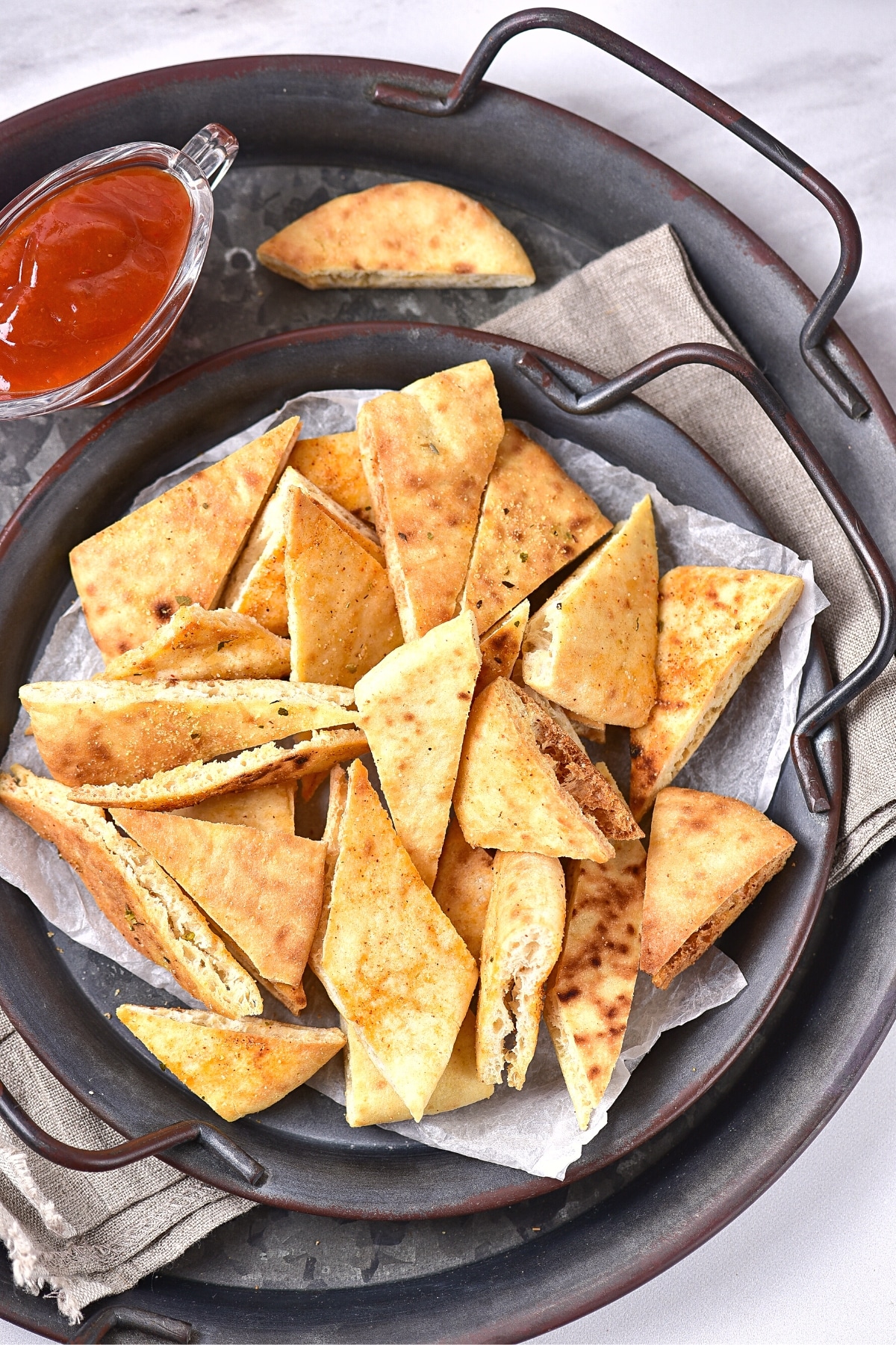 Gluten-free pita chips in metal serving dish.