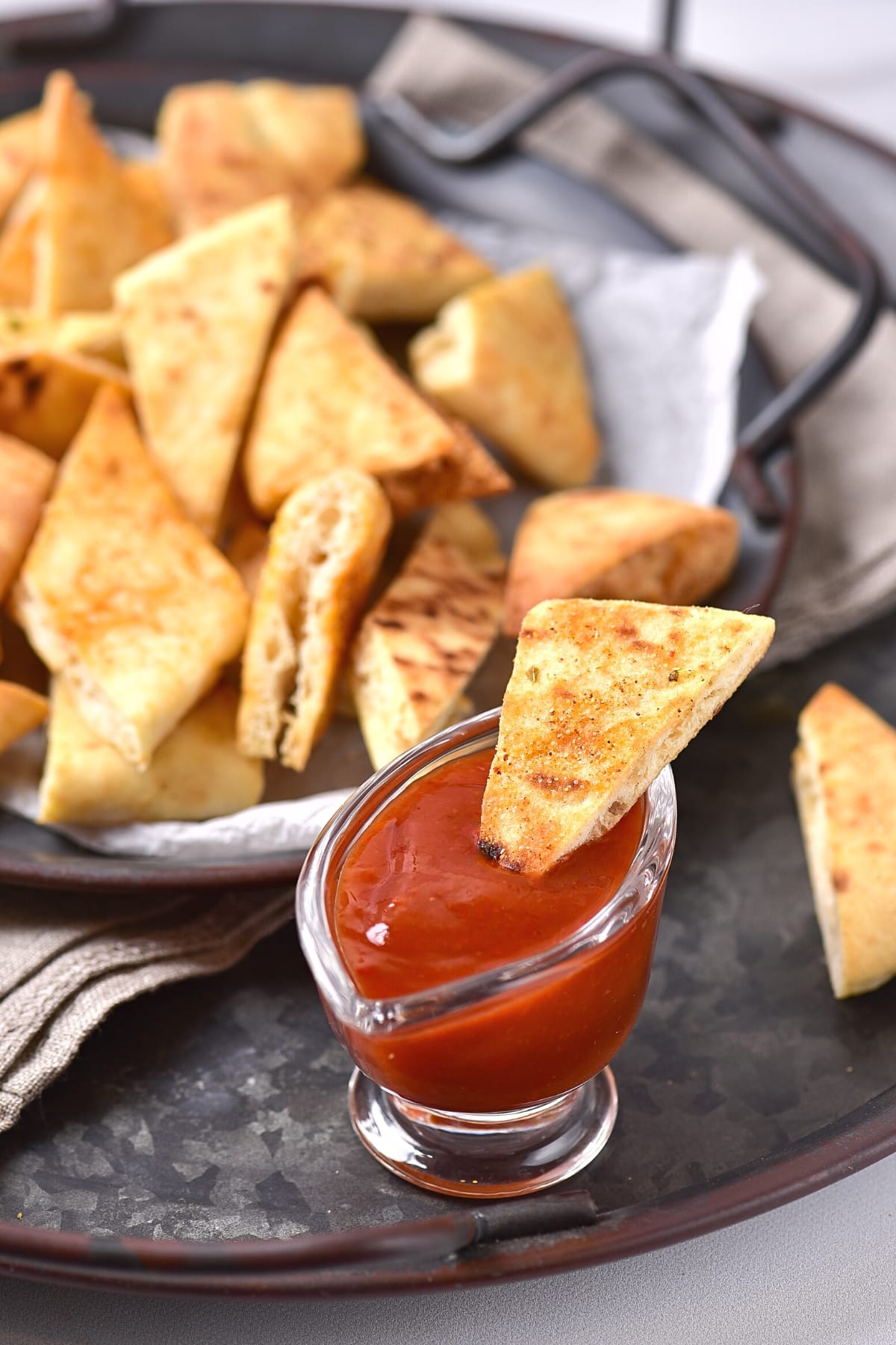 Dipping a gluten-free pita chip into salsa.