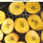 Crispy plantain chips in an air fryer basket.