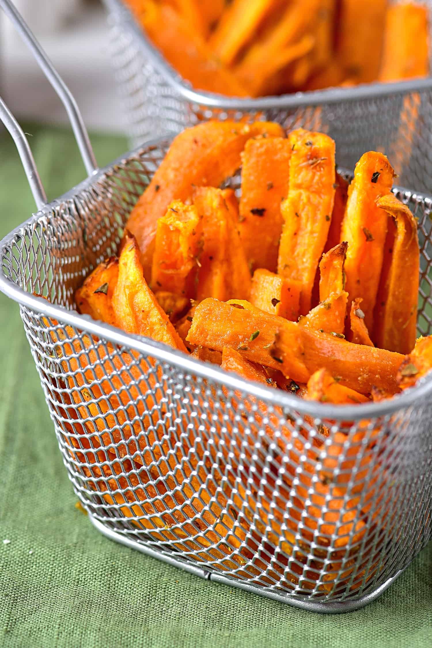Up close shot of a metal basket with sweet potato wedges.