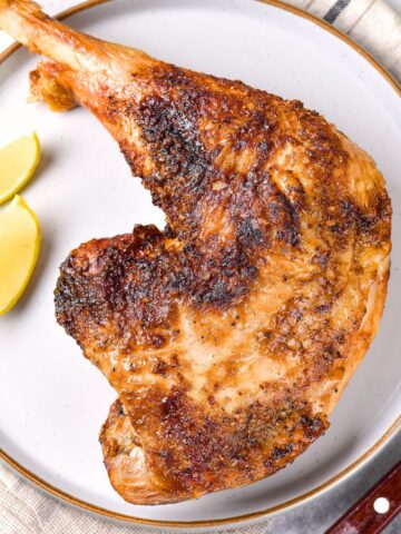 Turkey quarter and lemon wedges on a plate