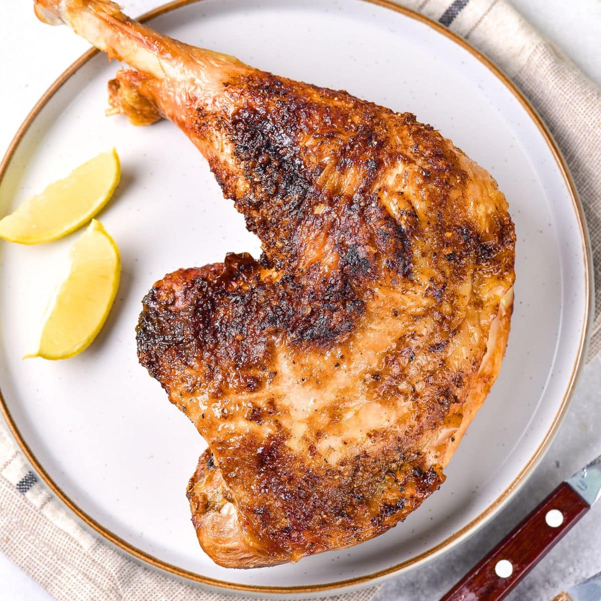 Turkey quarter and lemon wedges on a plate