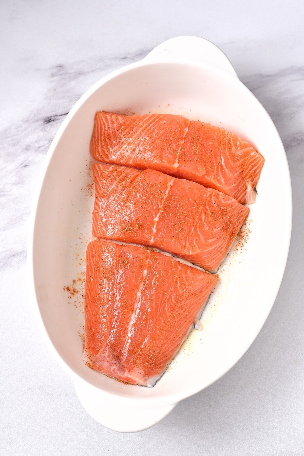 Fresh salmon pieces in white bowl.