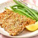 Almond crusted salmon with green beans on plate.