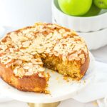 Half-eaten almond flour apple cake with green apples in background