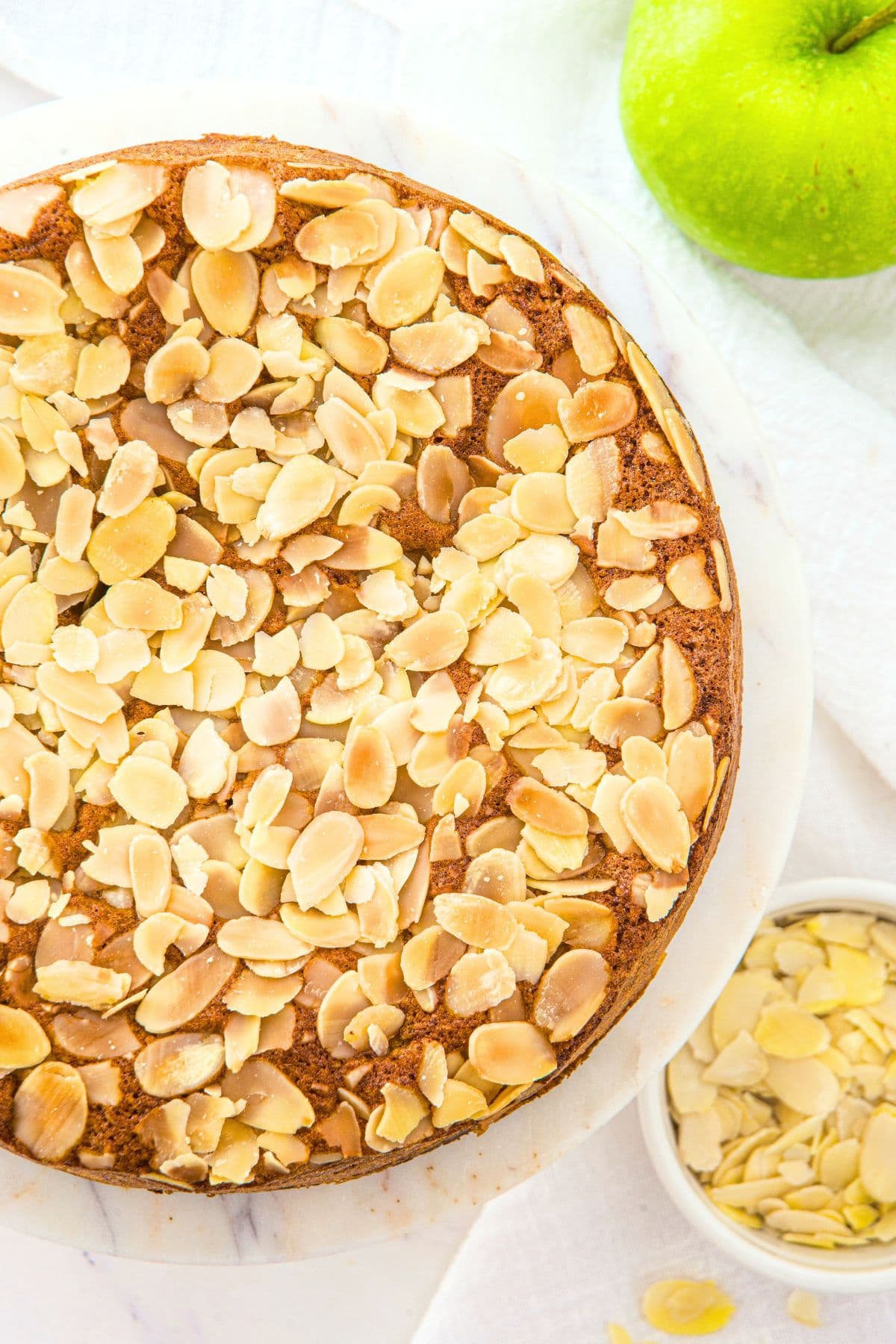 Top down view of apple cake with almond flour on cake stand