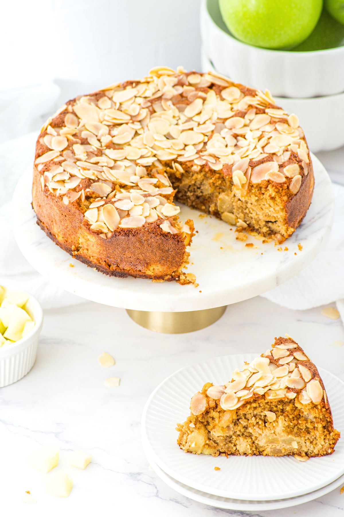 Half-eaten gluten-free apple cake with almond flour on cake stand