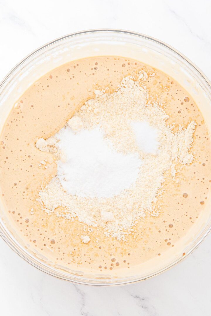 Flour mixture on top of pale brown cake batter