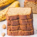 A stack of sliced banana bread on parchment paper.