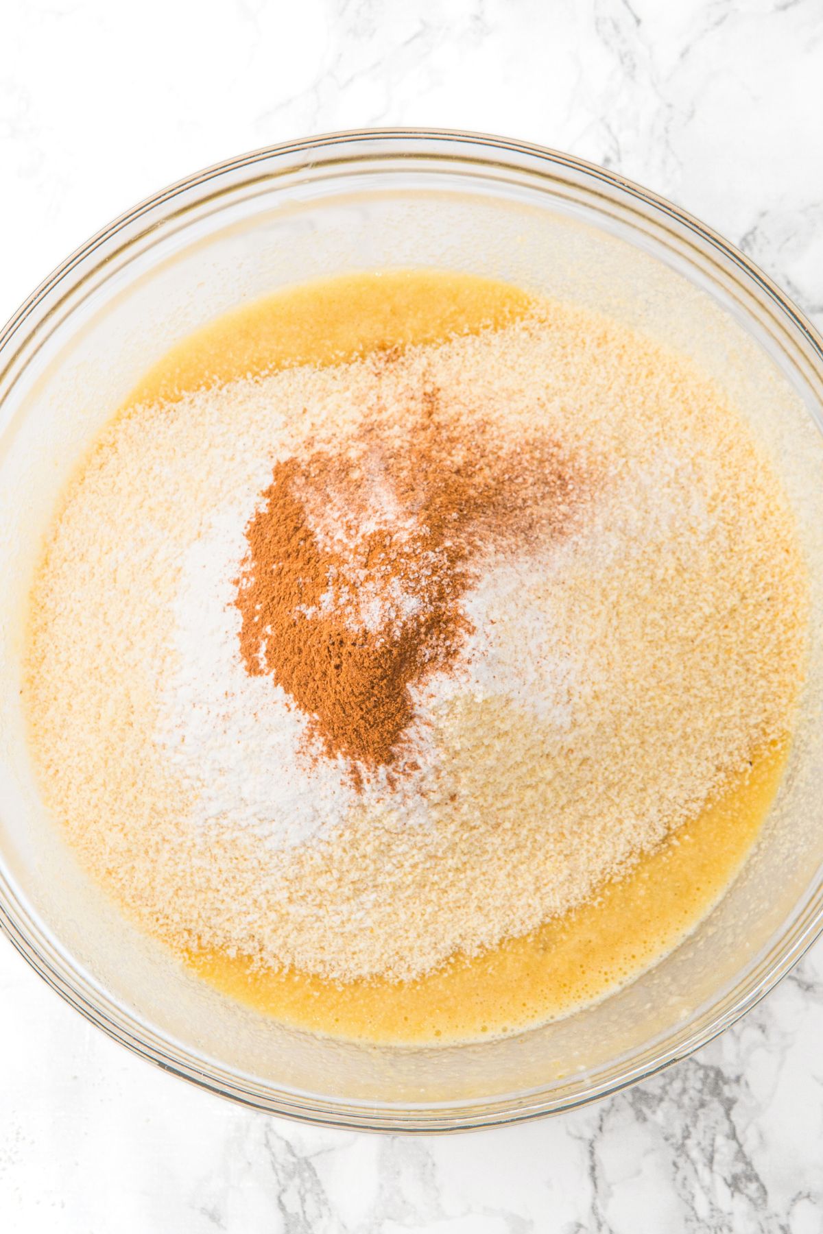 Flour mixture on top of pale yellow liquid mixture
