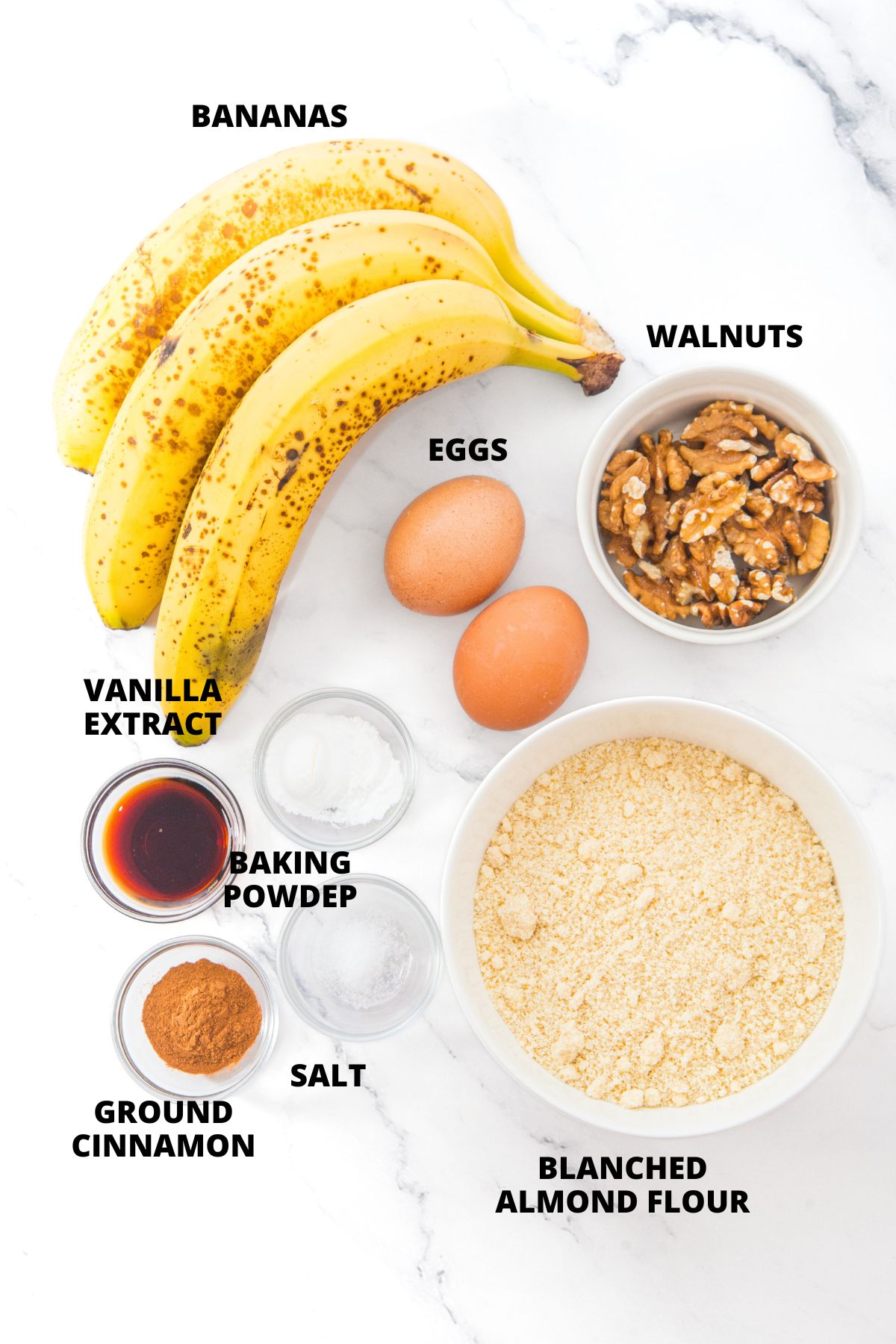 Ingredients for almond flour banana nut muffins recipe laid out on marble board.