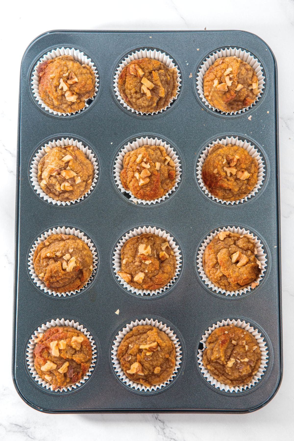 Freshly baked almond flour banana muffins in pan.