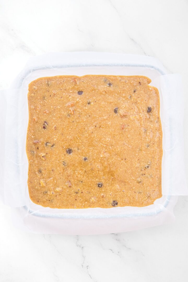 Almond flour blondie batter in glass baking pan.