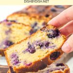 Hand holding up a slice of blueberry almond bread