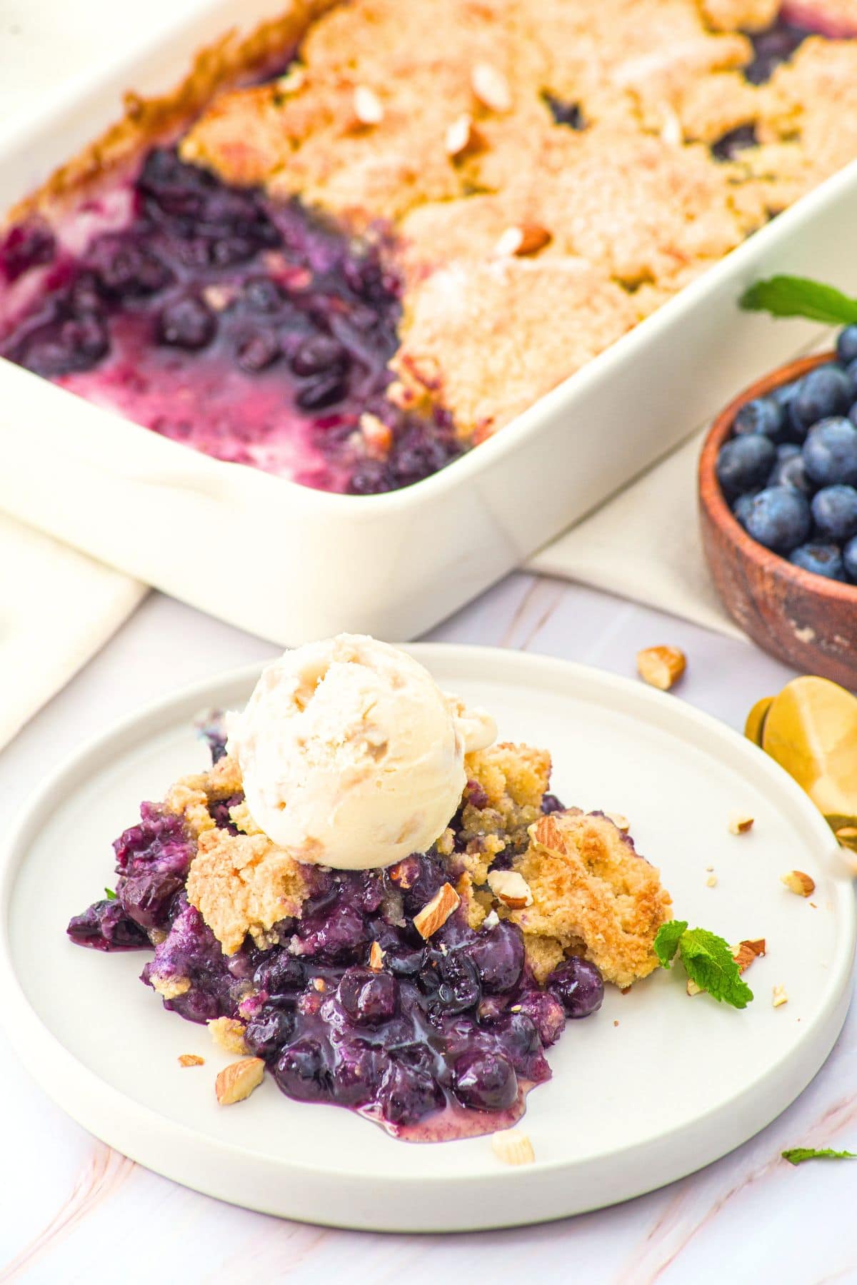 A plate of blueberry cobbler topped with ice cream