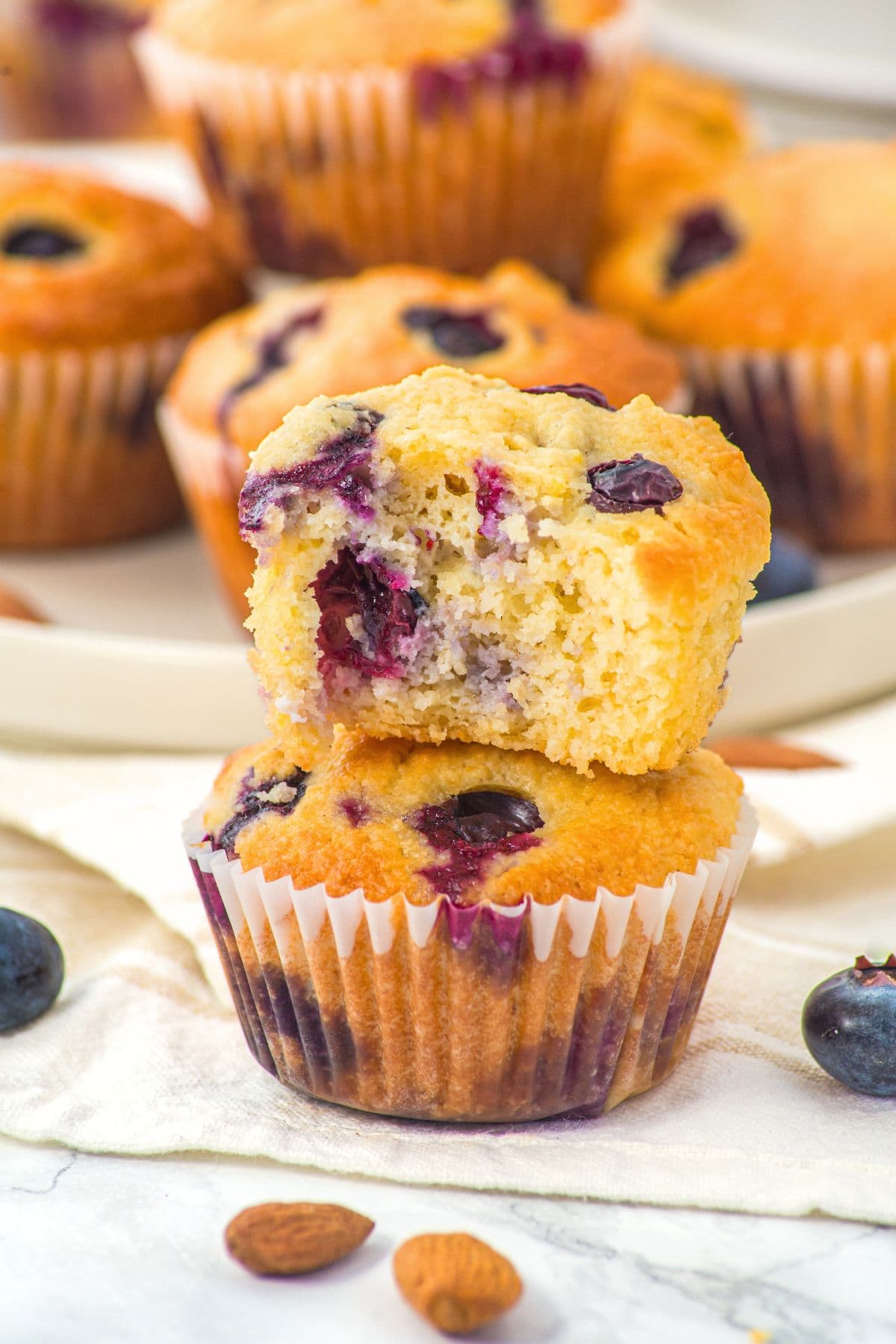 A stack of half-eaten almond flour muffins with blueberries