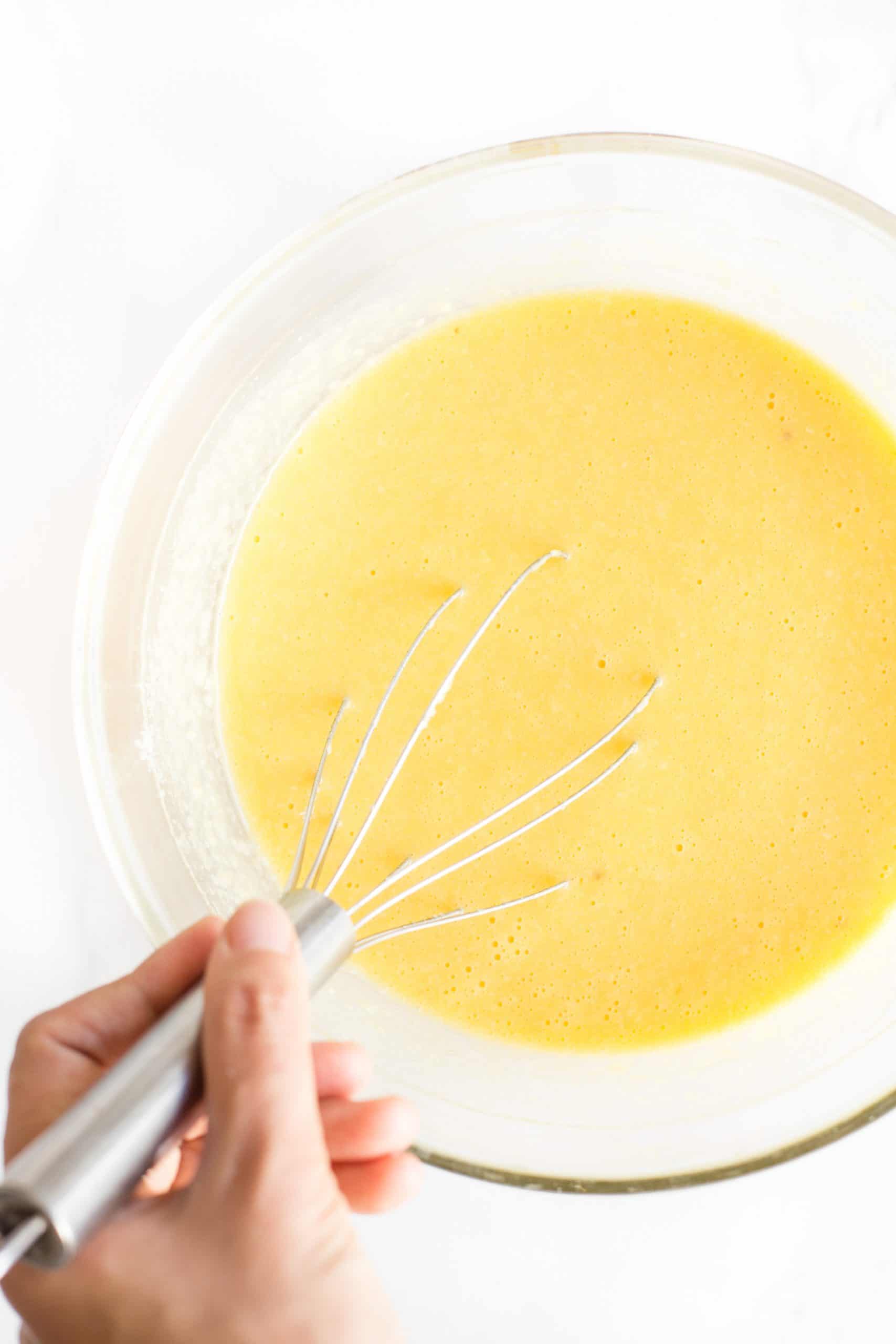 Hand whisking quick bread batter in a large bowl.