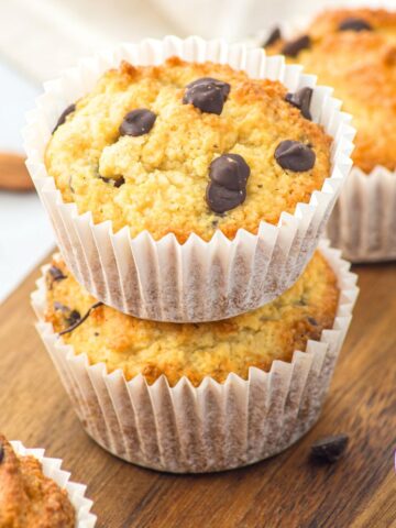 A stack of almond flour chocolate chip muffins on wooden board