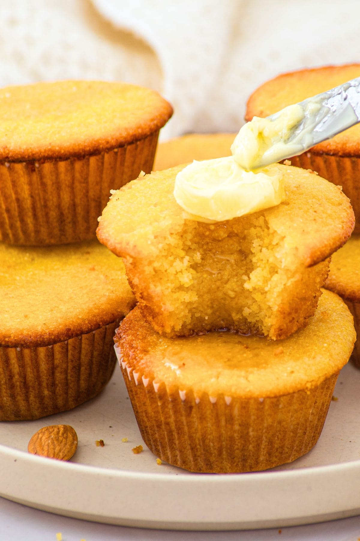 Smearing butter on almond flour corn muffins