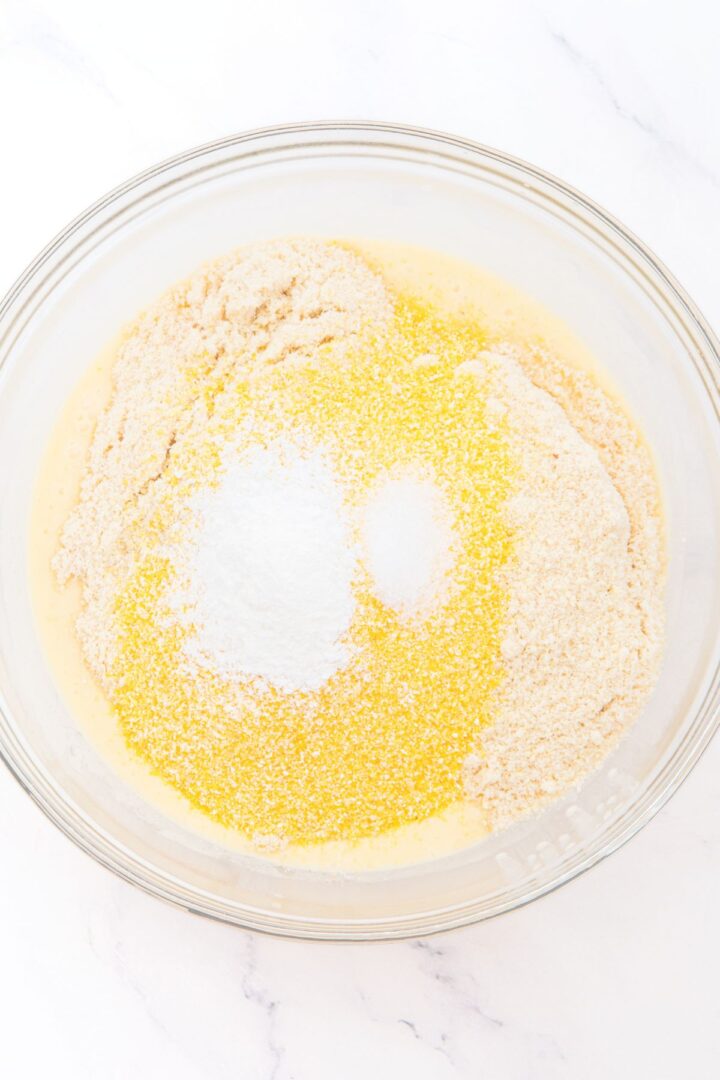 A bowl with cornmeal, blanched almond flour, baking powder and salt