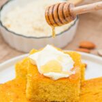 Drizzling maple syrup over cornbread spread with butter.