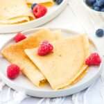 A plate of almond flour crepes topped with fresh raspberries