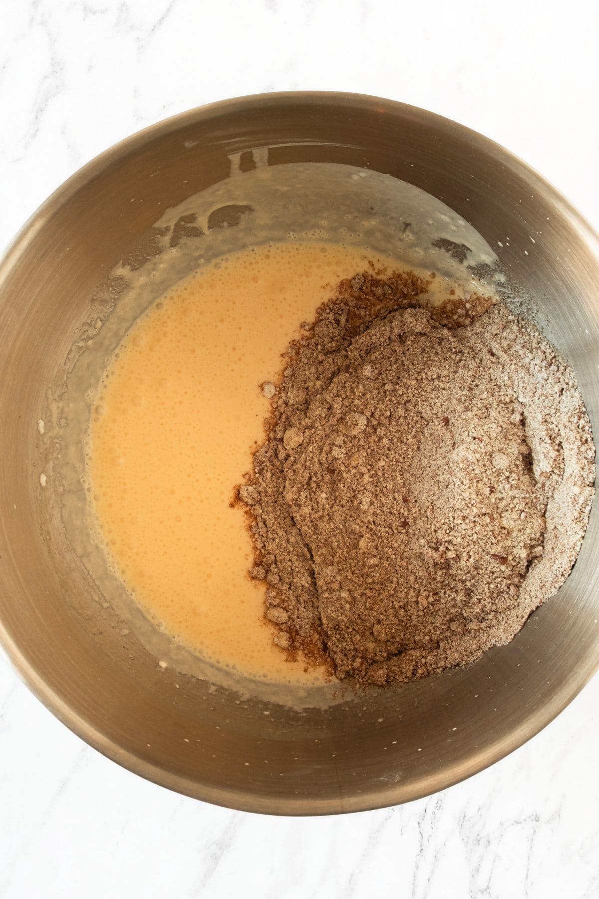 Combining flaxseed mixture and pale yellow liquid in metal bowl