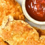 A plate of crispy almond flour chicken and ketchup