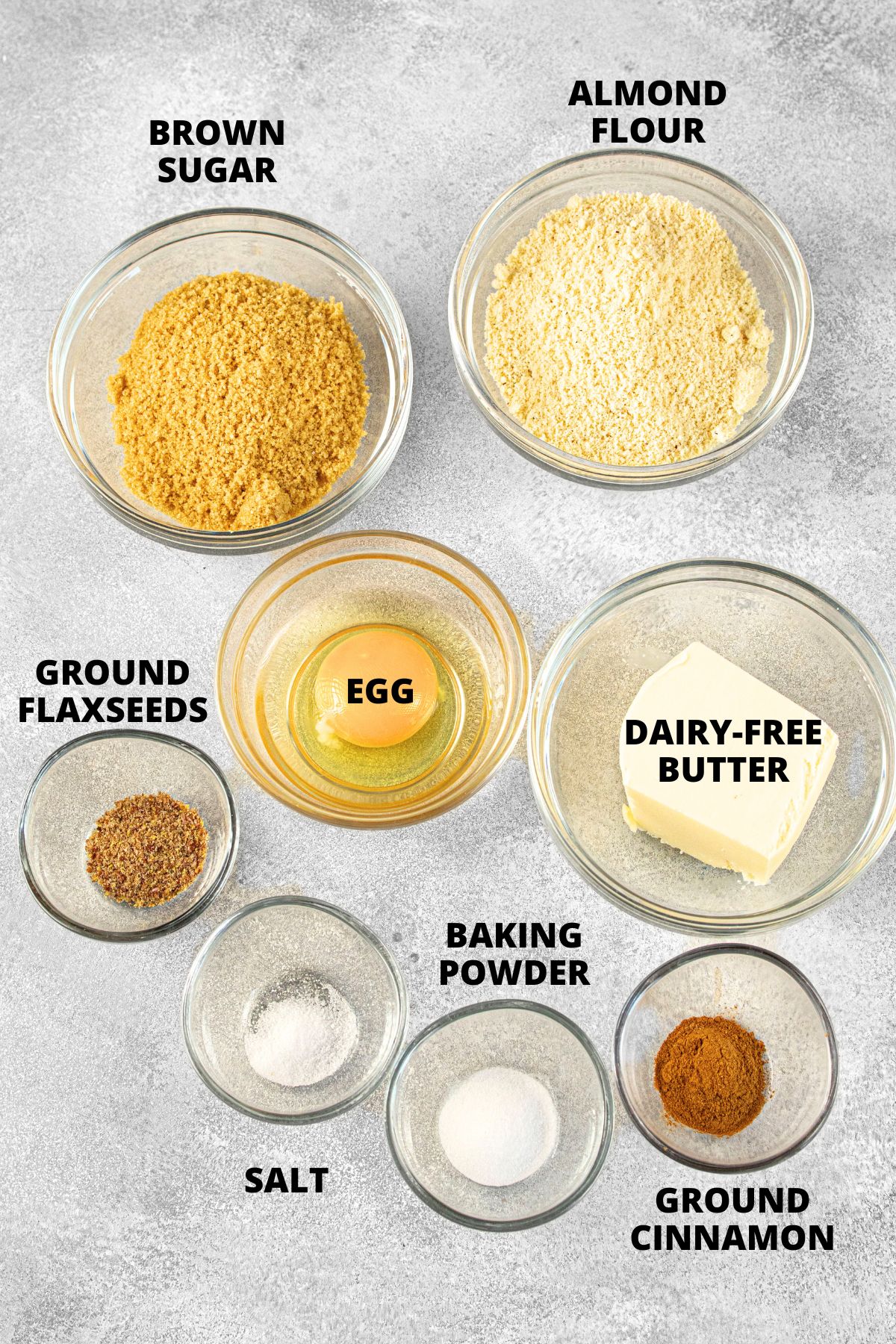 Ingredients for almond flour graham crackers recipe laid out on grey board.