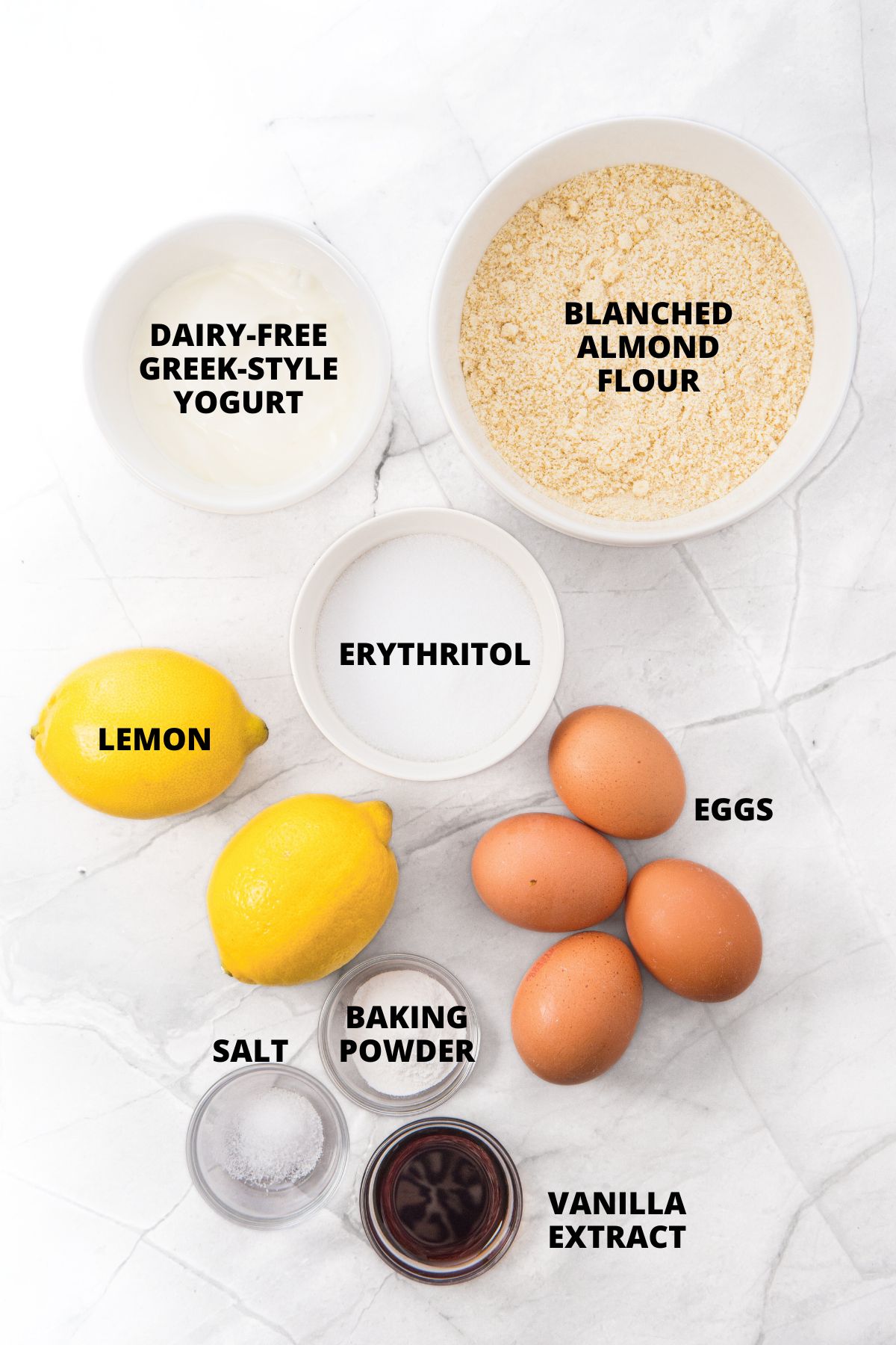 Ingredients for almond flour lemon loaf recipe laid out on marble board.