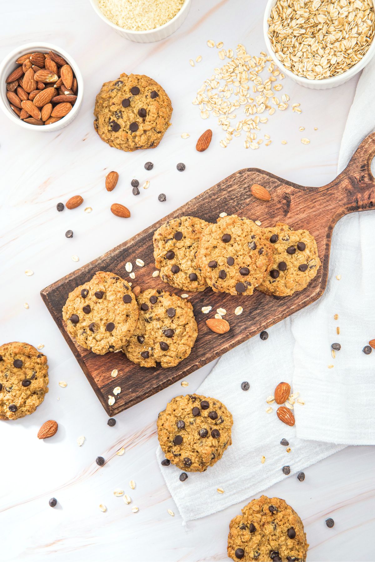 Top down view of chocolate chip almond flour and oatmeal cookies on wooden board.
