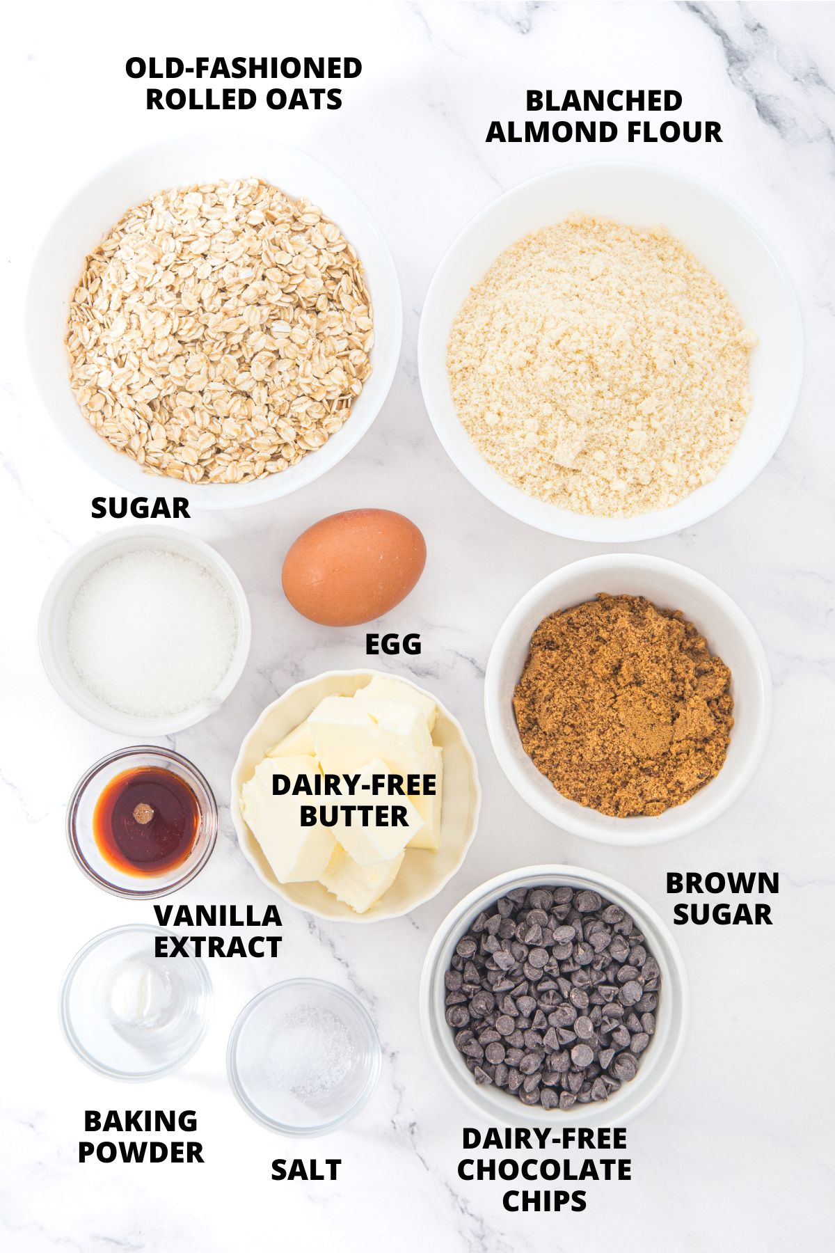 Ingredients for almond flour oatmeal cookies recipe laid out on marble board.