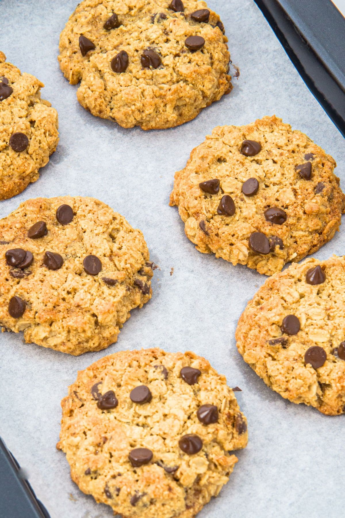 Up close view of cookies on parchment-lined cookie sheet.