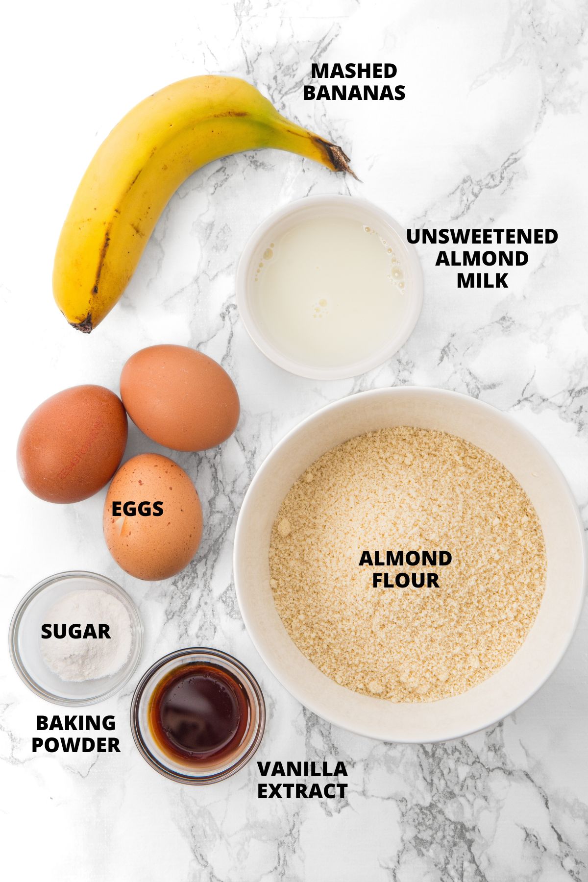 Ingredients for almond flour banana pancakes recipe laid out on marble board.