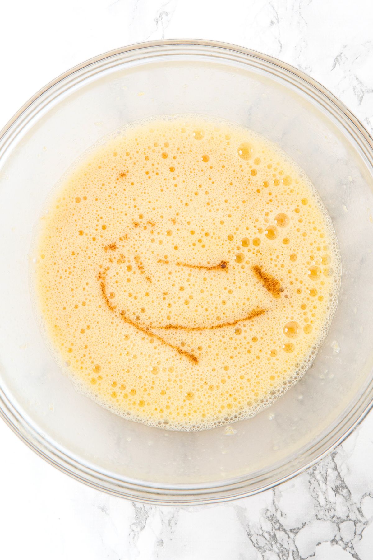 Light yellow liquid mixture drizzled with vanilla extract.