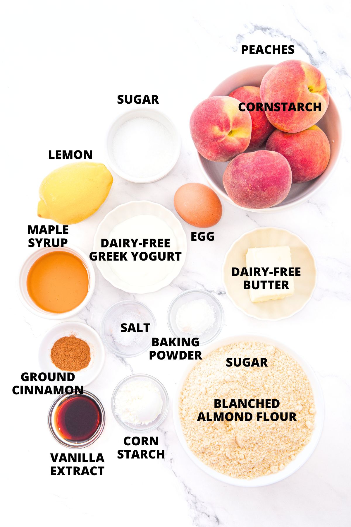 Almond Flour Peach Cobbler Recipe (Gluten-Free, Dairy-Free) Ingredients for almond flour peach cobbler recipe laid out on marble board.