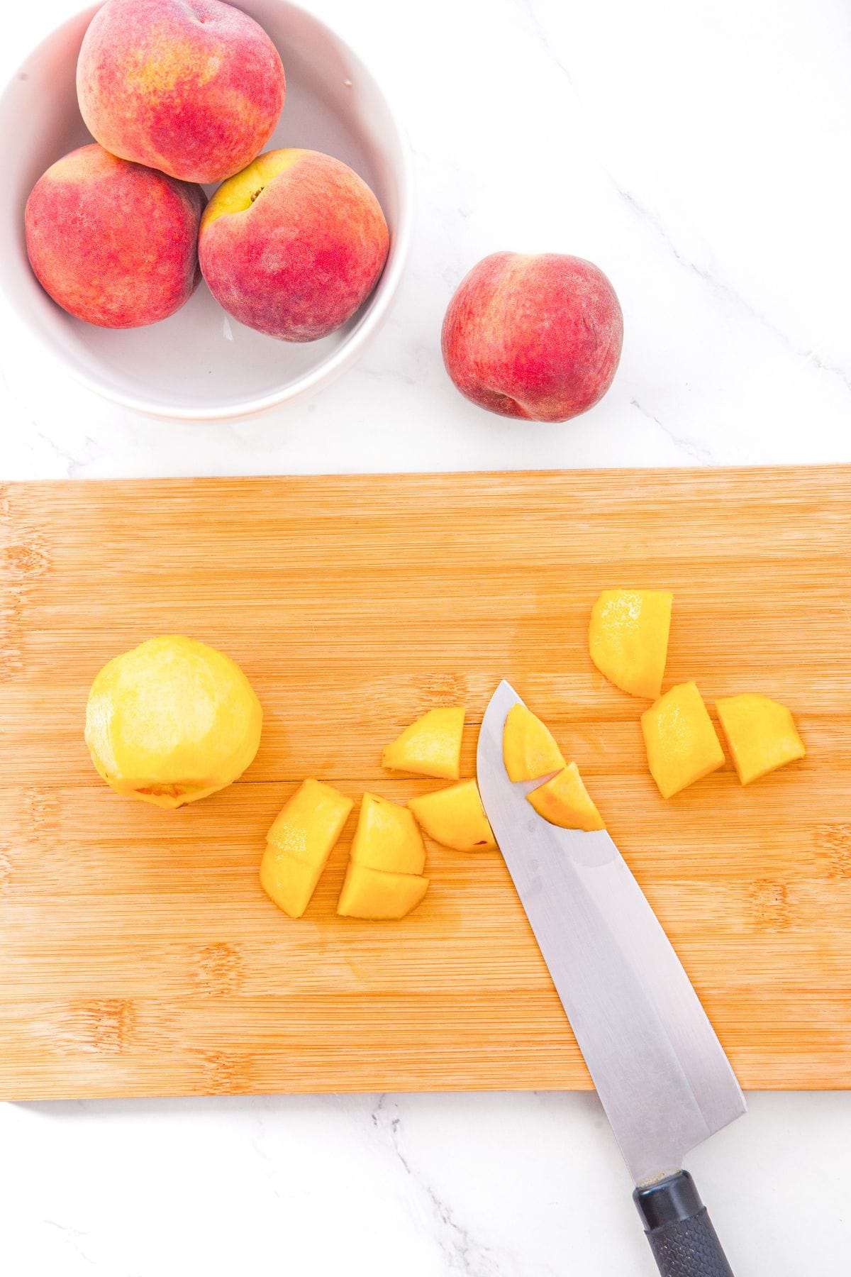 Gluten-Free Peach Cobbler with Almond Flour Cutting fresh peaches on wooden board