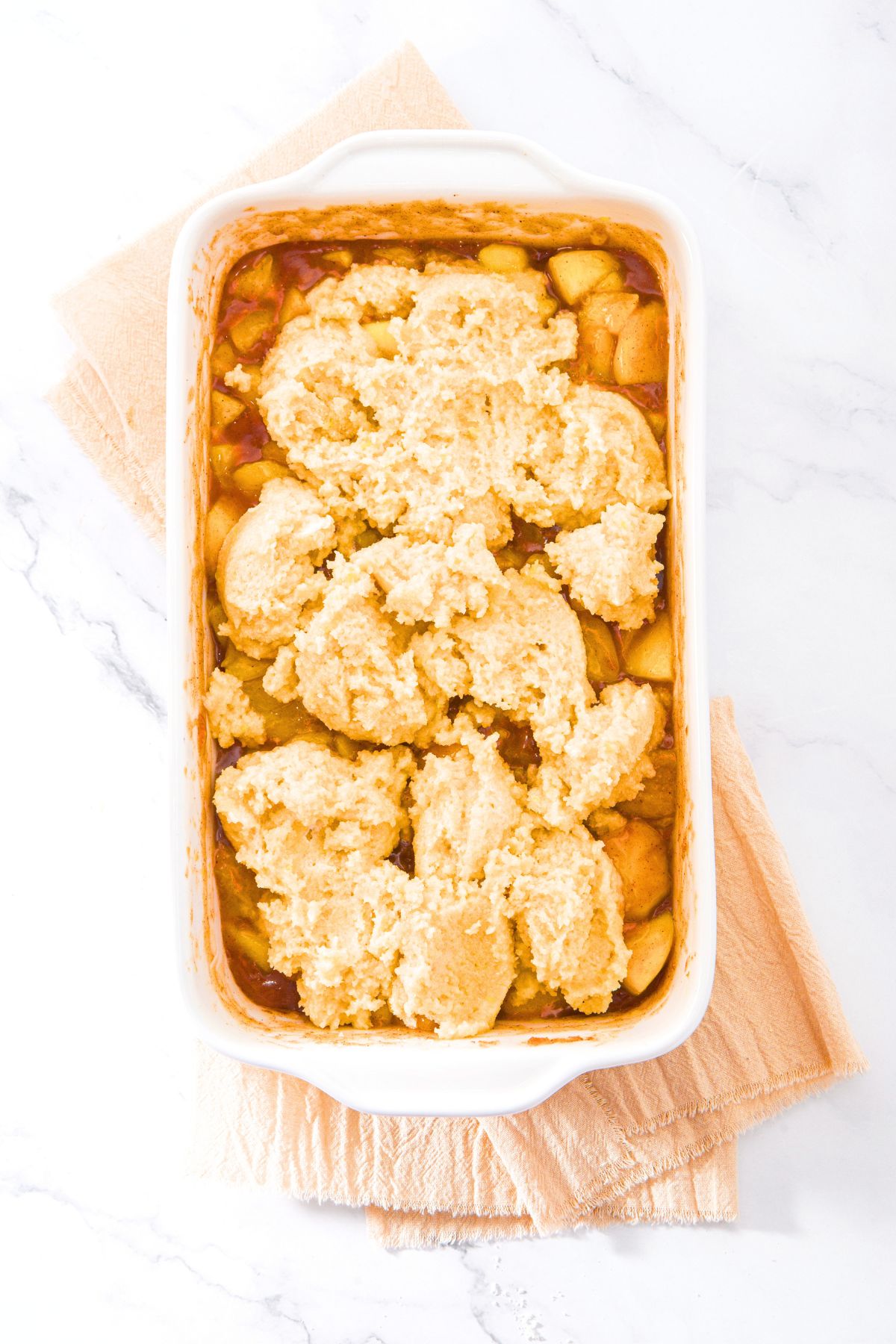Gluten-Free Dairy-Free Peach Cobbler Biscuit topping on top of baked peaches.